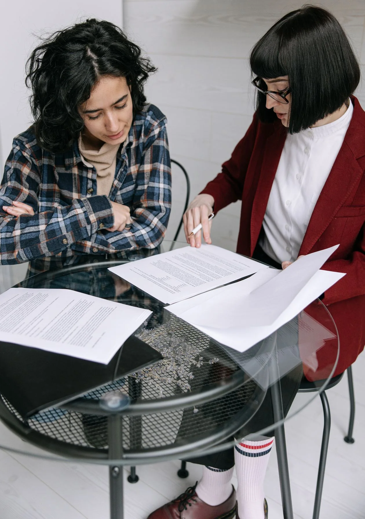 Two women discussing client documents together at a table.
